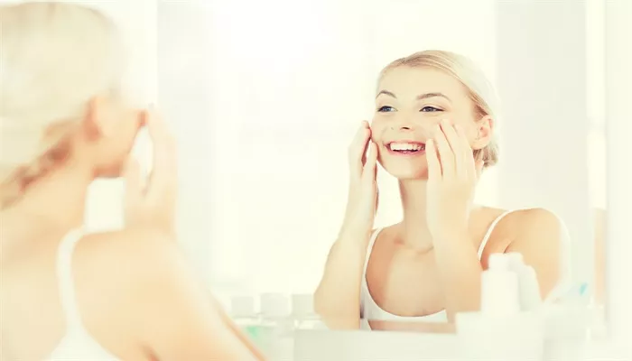 摄图网_300419905_banner_美丽,皮肤护理人的微笑的轻妇女应用奶油镜子家里的浴室快乐的女人浴室用奶油洗脸（企业商用）.jpg